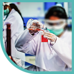 Student in PPE pouring red liquid into beaker