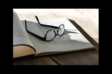 Open book with glasses on top