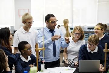 Secondary students doing practical work with their teacher.