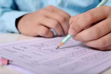 Student hands over a question paper