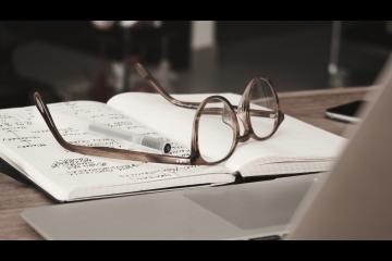 Book open with glasses on top