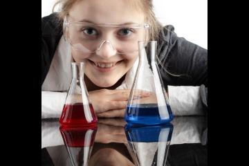 Student looking through conical flasks