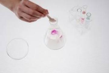 chemicals being added to a conical flask