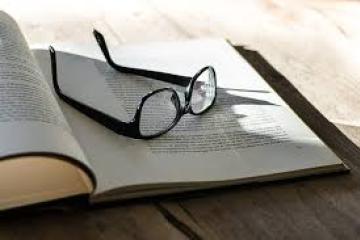 Open book with glasses on top